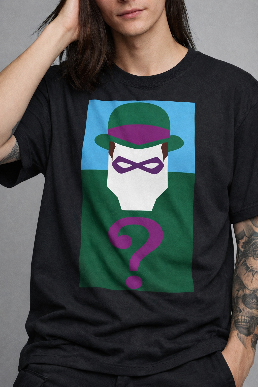 t-shirt-enigmista-riddler-pop-art-stampa-dtf.jpg Uomo con capelli lunghi e tatuaggi indossa t-shirt nera con stampa DTF geometrica dell'Enigmista e punto interrogativo viola.